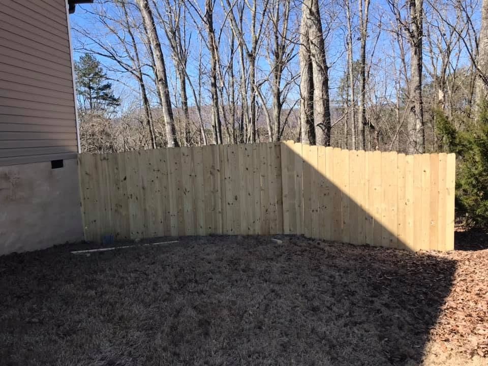 Completed wood privacy fence wrapping around the backyard